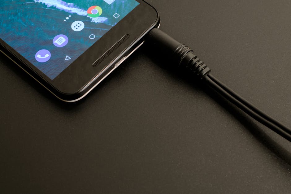 Close de um smartphone sendo carregado, exibindo uma interface moderna em um cenário escuro.