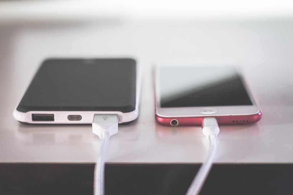 Dois smartphones carregando lado a lado em uma mesa. Cenário moderno e tecnológico.