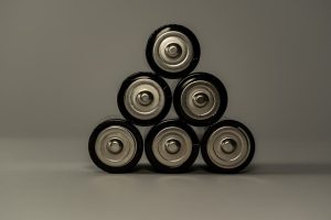 Pilhas AA metálicas empilhadas em forma de pirâmide, simbolizando poder e armazenamento de energia.