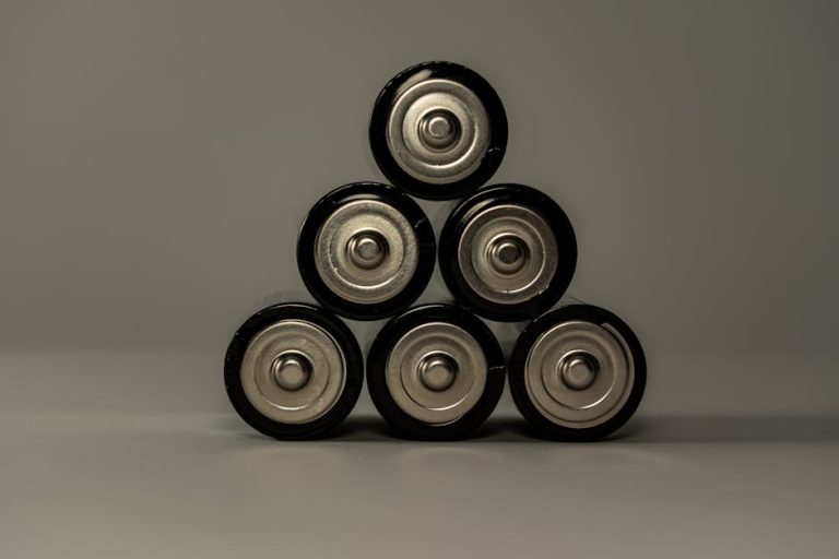 Pilhas AA metálicas empilhadas em forma de pirâmide, simbolizando poder e armazenamento de energia.