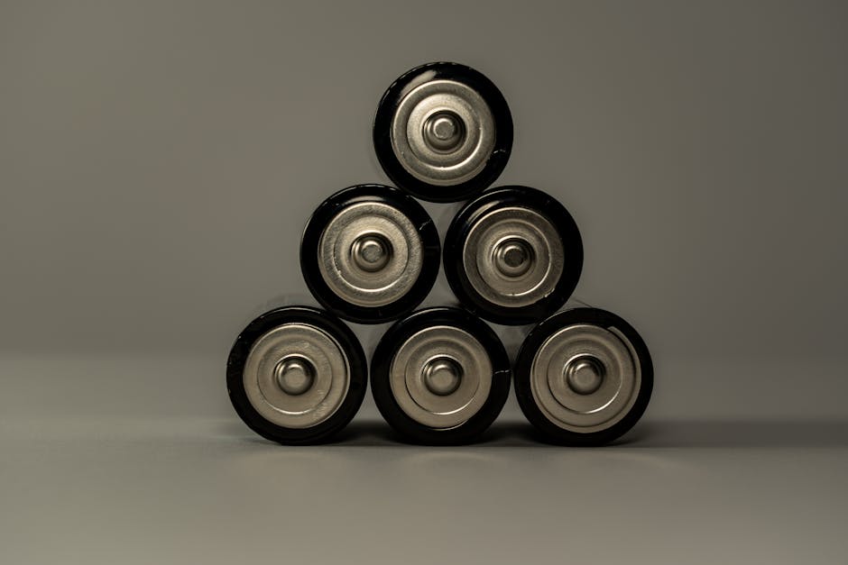 Pilhas AA metálicas empilhadas em forma de pirâmide, simbolizando poder e armazenamento de energia.